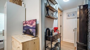 A compact kitchen with a wooden cabinet, a coffee machine, and a black shelf with dishes. - Cozy Studio Just 5 Minutes from Miami Airport! Comes with 1 Free Parking Space. (Miami Springs)