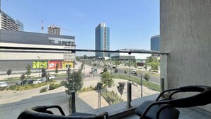 Un balcón con vista a un estacionamiento y edificios.