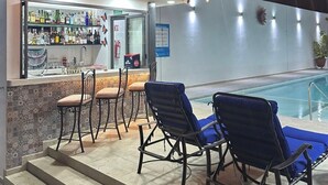 A bar area with a poolside seating arrangement and a bar counter. - LUXOR & CONDO OJOS ESPAÑOLES (Chapala)
