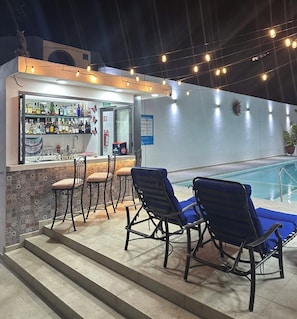 A bar area with a poolside seating arrangement and a bar counter. - LUXOR & CONDO OJOS ESPAÑOLES (Chapala)