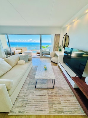Suite studio panoramique, 1 très grand lit et 1 canapé-lit, balcon, vue sur l’océan | Aire de séjour | Téléviseur connecté de 65 po avec télévision par câble