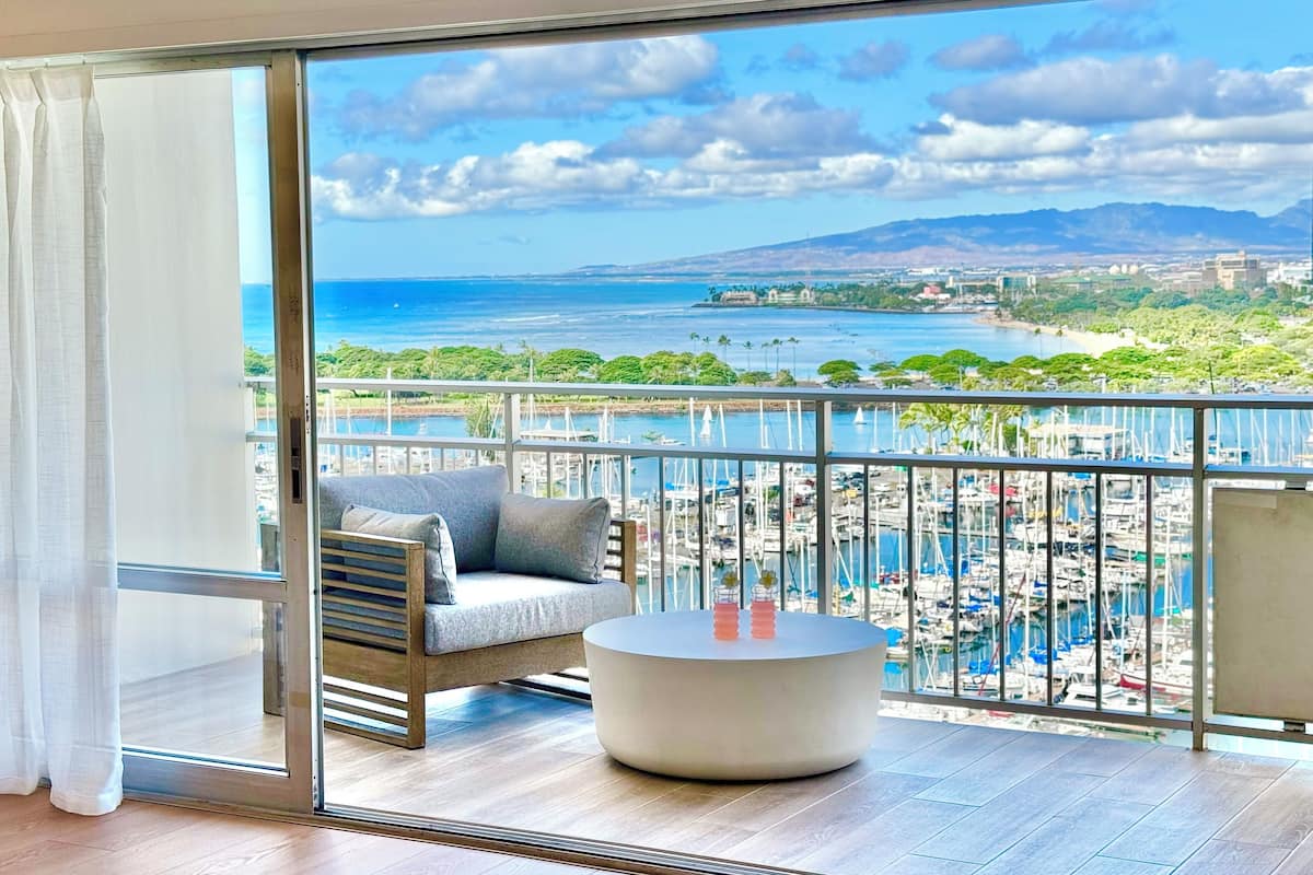 A balcony with a view of the ocean and a marina.