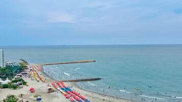An aerial view of a beach with rows of umbrellas and beachgoers.