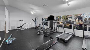 A gym with treadmills, elliptical machines, and weight equipment.