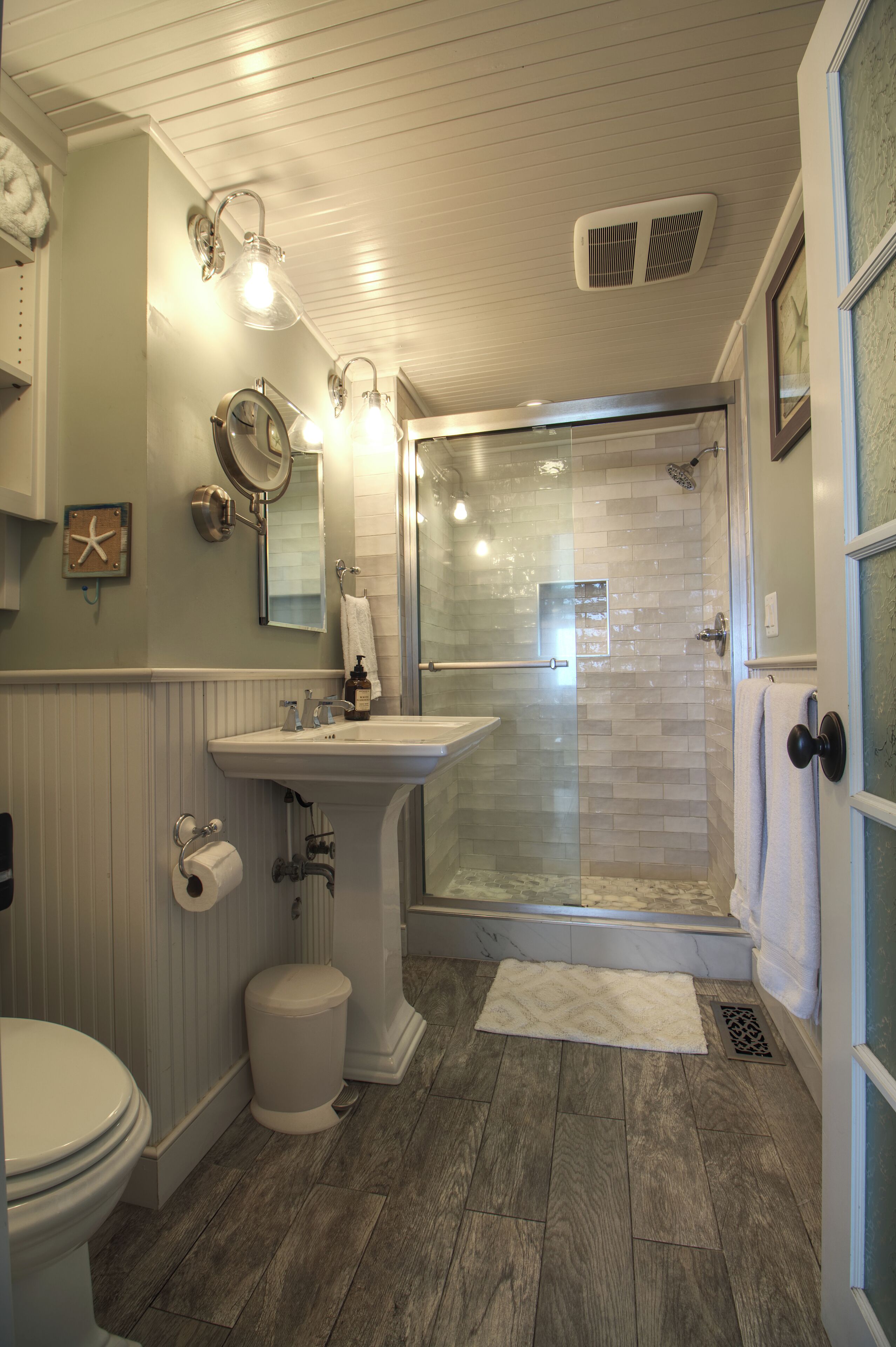 A bathroom with a toilet, sink, and glass-enclosed shower.