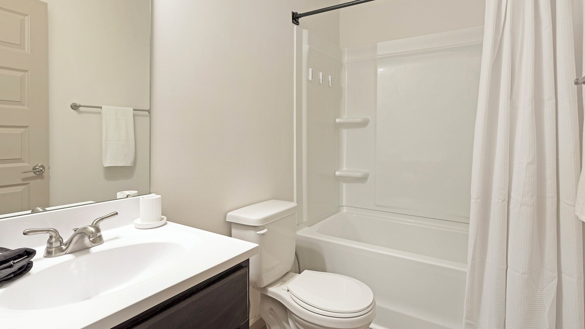 A modern bathroom with a white sink, toilet, and bathtub.