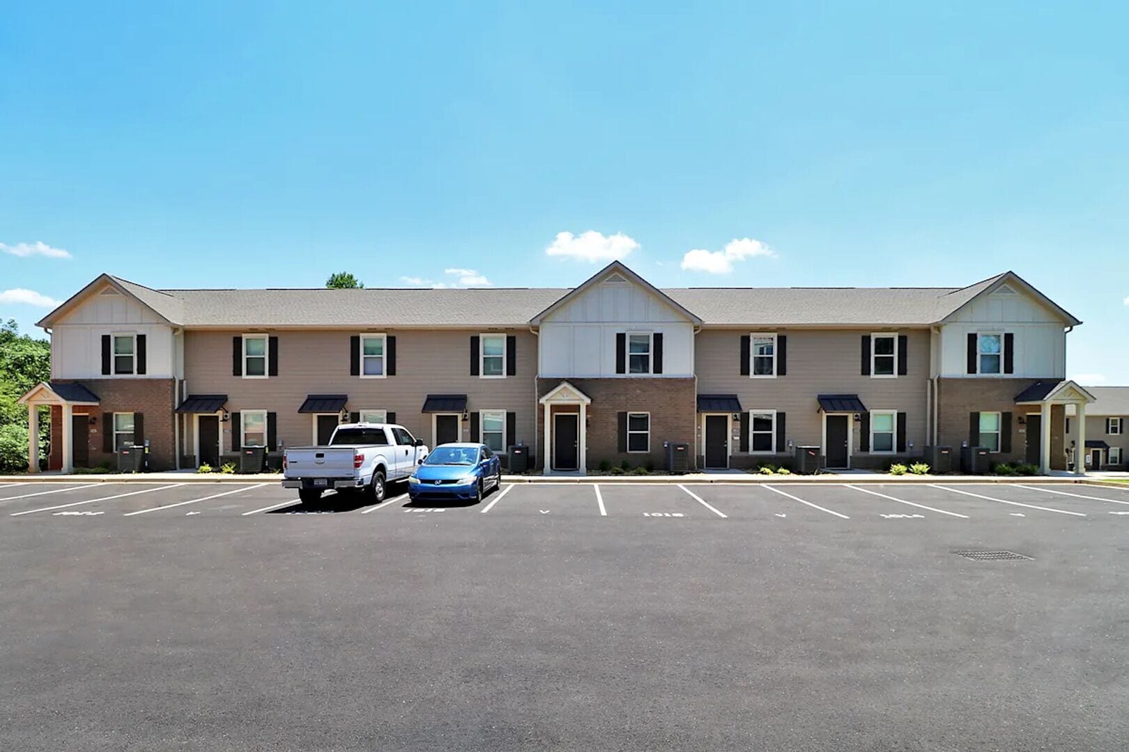 A multi-story hotel with a parking lot in front.