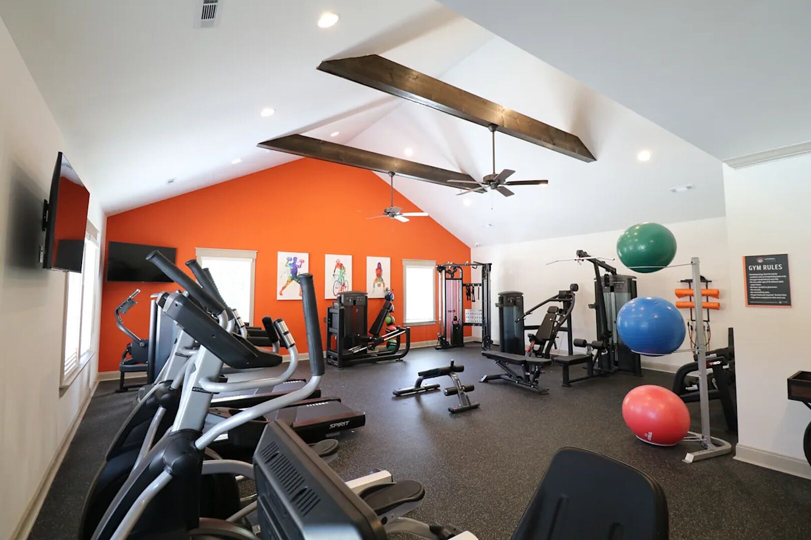 A gym with treadmills, weight machines, and exercise balls.