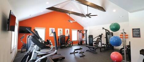 A gym with treadmills, weight machines, and exercise balls.