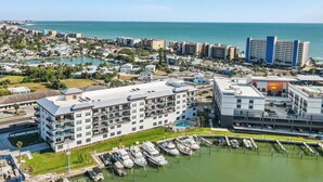Ein Küstenhotel mit mehreren Etagen, einer Marina mit Booten und Blick auf den Ozean.