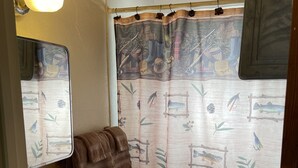 A small bathroom with a toilet, sink, and a mirror. There is a towel hanging on the wall. - Stoney River Lodge - Unit 7 - Fisherman (Loveland)