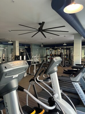 A gym with various exercise equipment including treadmills and a ceiling fan. - Chic 1-bedroom apartment with fitness room and AC in enjoyable Sandy Springs (Sandy Springs)
