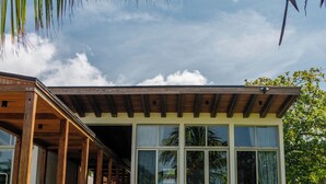Een modern huis met een overdekte veranda, grote ramen en een verzorgd gazon.