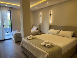 A modern hotel room with a large bed, a bedside table, a chair, and a window with curtains.
