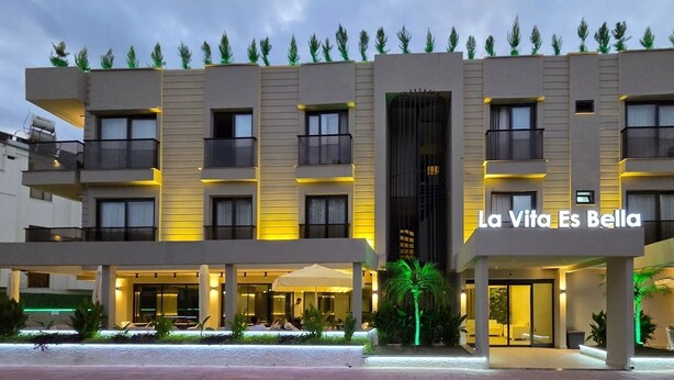 Ein mehrstöckiges Hotel im modernen Stil, mit Balkonen und einem zentralen Eingang.