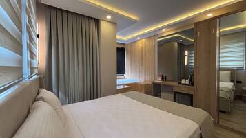 Une chambre d’hôtel moderne équipée d’un grand lit, d’un bureau, d’un miroir et d’un espace douche.