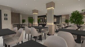 A modern restaurant with multiple tables and chairs, a visible WC sign, and decorative plants. - La Vita Es Bella (Konyaalti)