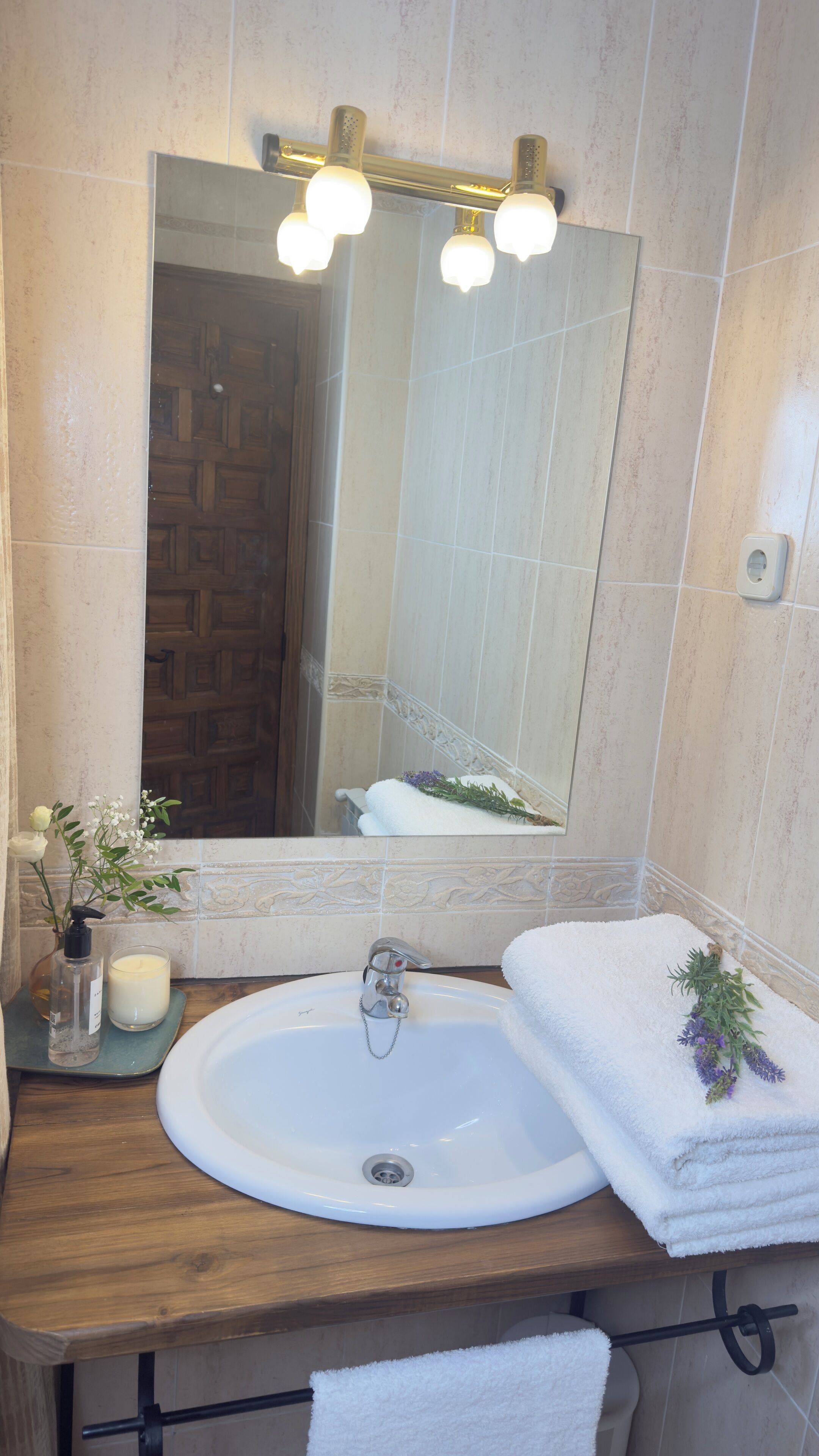 Une salle de bain avec un lavabo blanc, un miroir et un espace douche.