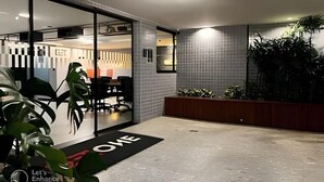 A modern hotel lobby with a reception desk, a glass partition, and a welcome mat. - Get one (Joao Pessoa)