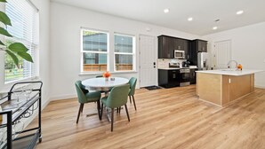 A modern kitchen with dark cabinets, a white countertop, and a central island. - Stylish new build 2BR/2BA getaway w/ gated parking (Memphis)