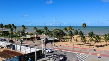 Una intersección frente a la playa con palmeras, una carretera y vistas al océano.