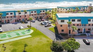 A coastal hotel with a parking lot, a pool, and a view of the ocean. - Oceanview 2 BR Unit 411 (St. Augustine)