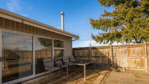 A patio with a table and chairs, a covered seating area, and a wooden fence. - Cozy Nook Twizel – A Charming Hideaway for Two or a Few (Twizel)
