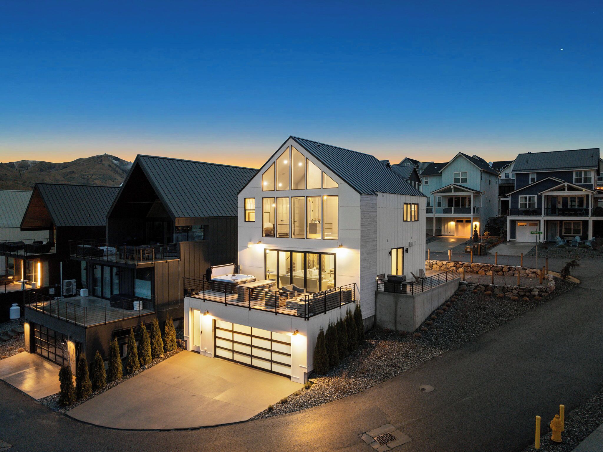 A modern two-story house with a garage, large windows, and a balcony.