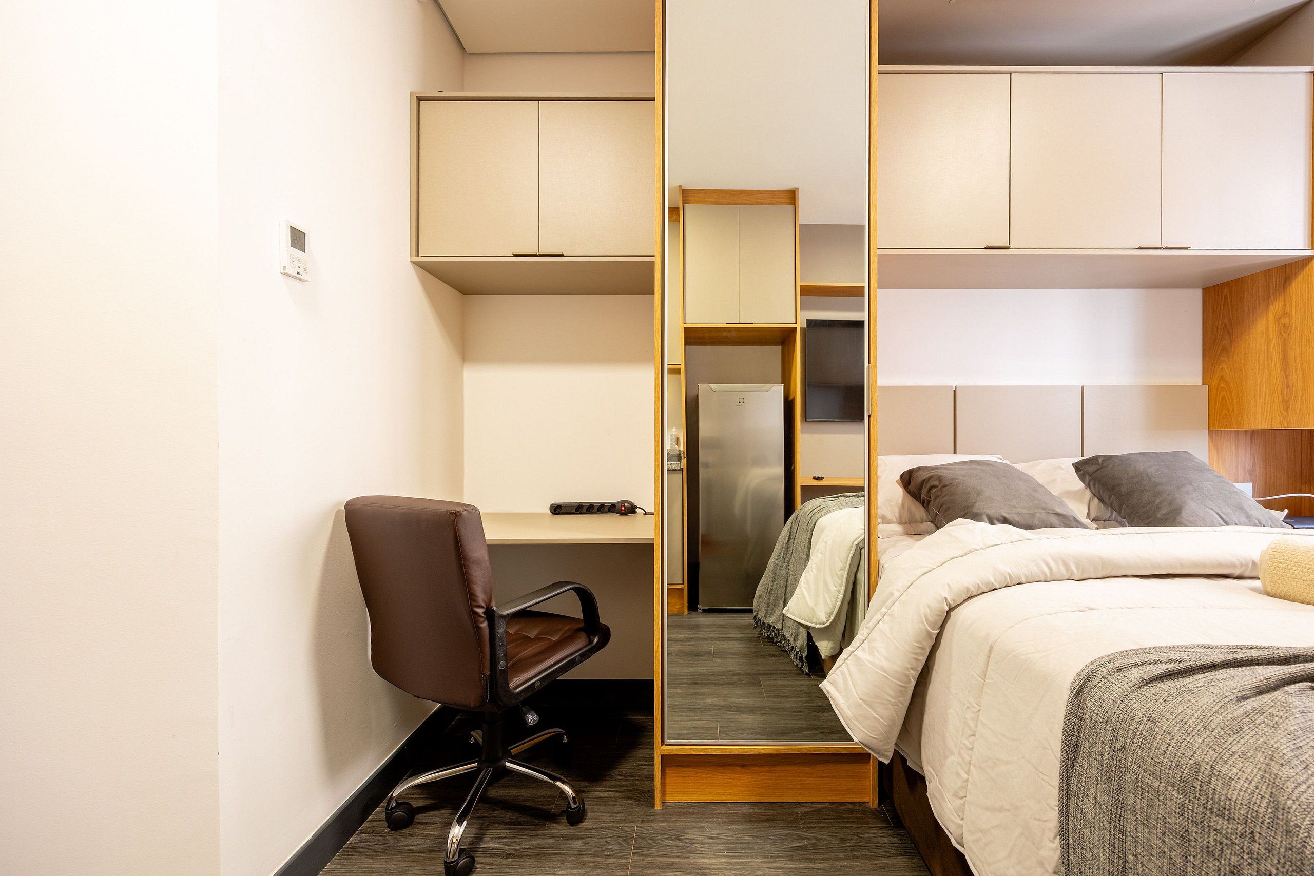 Una habitación de hotel pequeña con una cama individual, un escritorio y una silla.