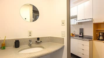 Een badkamer met een granieten aanrecht, een wastafel, een spiegel en een toilet.