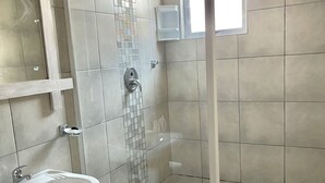 A shower with a glass door, a sink, and a small window. - Cosy Coastal Escape - Quiet Hideaway 7 minutes from the Sea (Swakopmund)