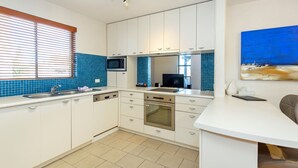 A modern kitchen with white cabinets, a built-in microwave, and a tiled backsplash. - Como Mezzanine Retreat (Como)