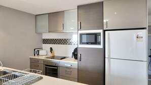 Eine kleine Küche mit Mikrowelle, Ofen und Kühlschrank.