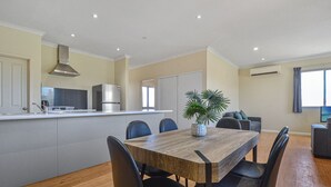 A modern apartment with a dining area, kitchen, and living space. - Marvellous McKay 3x2 Close to CBD (Port Hedland)