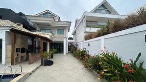 Un quartier résidentiel doté d’une piscine, d’un patio couvert et d’un jardin agrémenté de plantes à fleurs.