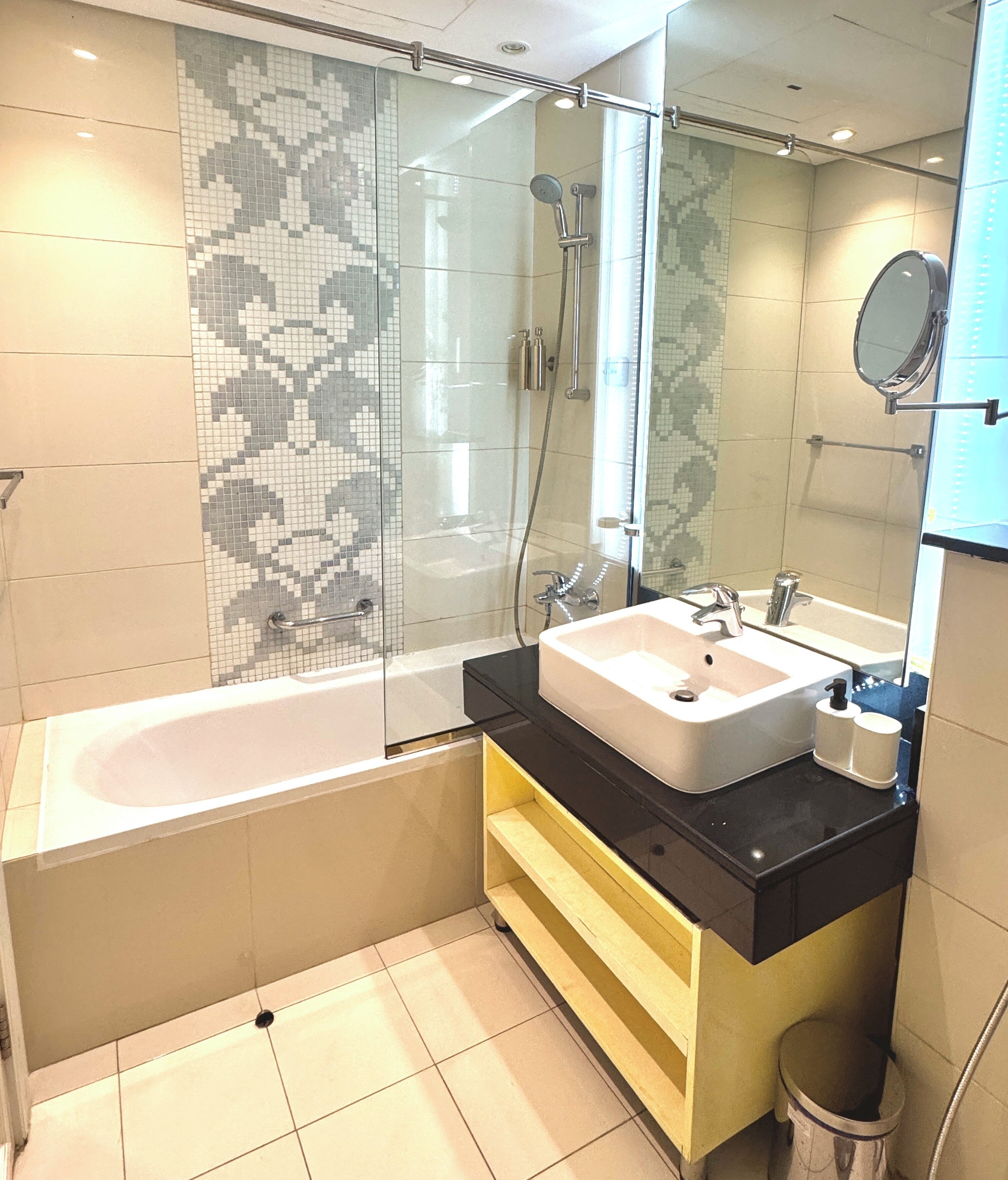 Een moderne badkamer met een douchecabine, een vrijstaand bad en een wastafel met spiegel.