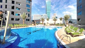 Ein Pool mit Blick auf moderne Gebäude im Hintergrund.