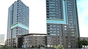 Ein modernes Hochhaus mit einer markanten, geometrischen Fassade und mehreren Balkonen.