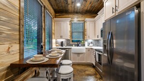 Una cocina moderna con paredes de madera, electrodomésticos de acero inoxidable y una isla central con taburetes.