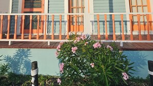 A two-story house with a porch, numbered 1710, featuring a decorative front door and windows.