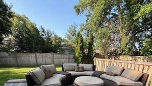 A wooden deck with a sectional sofa and ottoman. - Galactic Oasis Theme Home,  Marvelous 5-bedroom house with AC in Aurora, TV’s (Aurora)