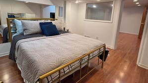 A bedroom with a bed, wooden flooring, a window, and recessed ceiling lights. - Galactic Oasis Theme Home,  Marvelous 5-bedroom house with AC in Aurora, TV’s (Aurora)