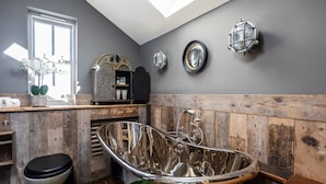 A bathroom with a vintage bathtub, a toilet, and a window with natural light. - The Cocktail Lounge - sleeps 2 guests  in 1 bedrooms (Nantwich)