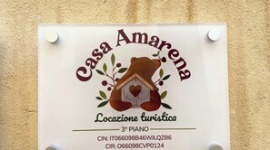Ein Schild mit dem Text 'Casa Amarena' und 'Locazione turistica', das einen Ort für Touristen kennzeichnet.