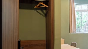 Una habitación con un armario de madera, una mesa y una silla.