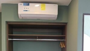 Una habitación con armario empotrado, aire acondicionado instalado en el techo y suelo de baldosas.