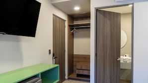 Un baño moderno con tocador verde, un espejo y un perchero para toallas.