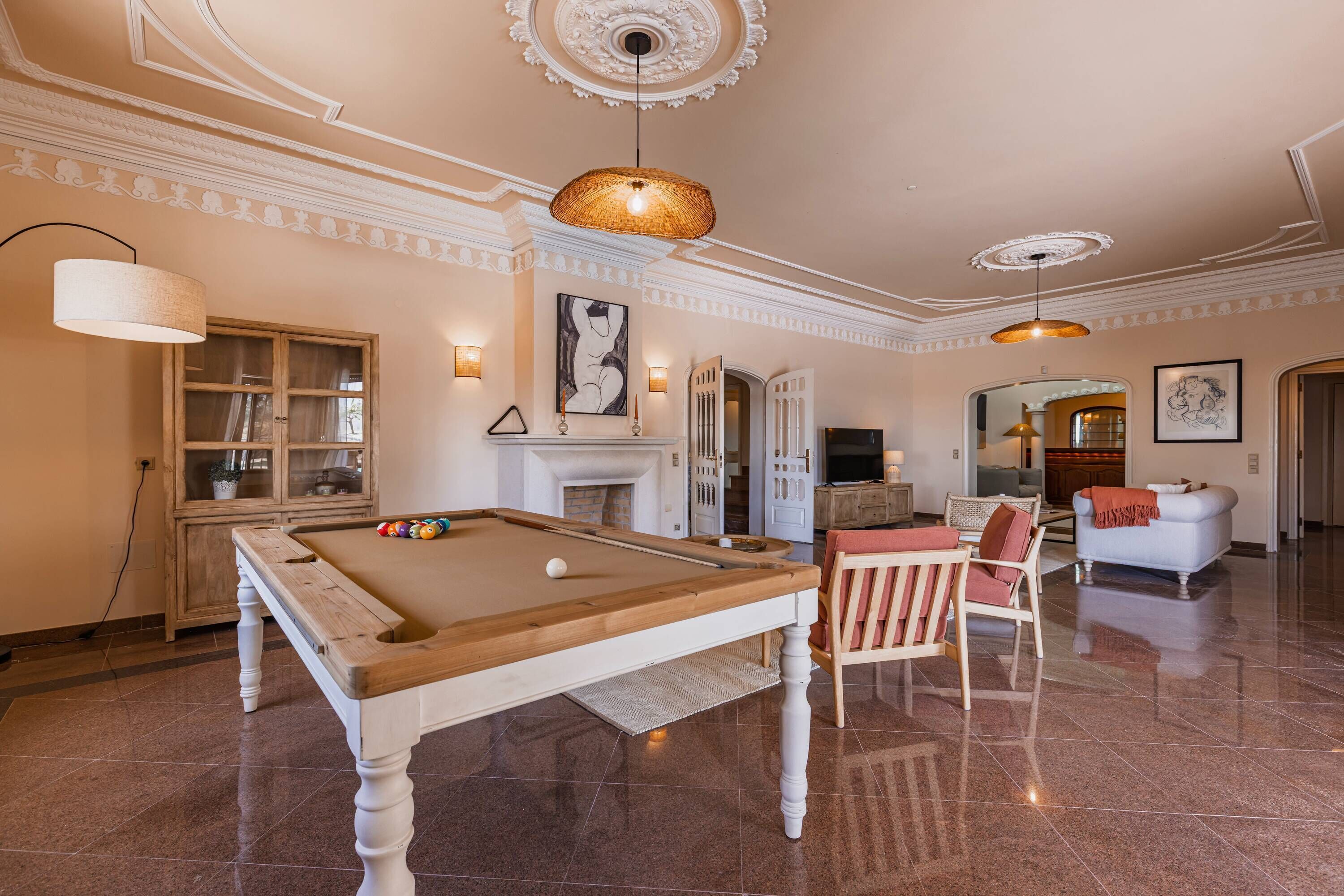 A spacious living area with a pool table, a fireplace, and a cozy seating area.