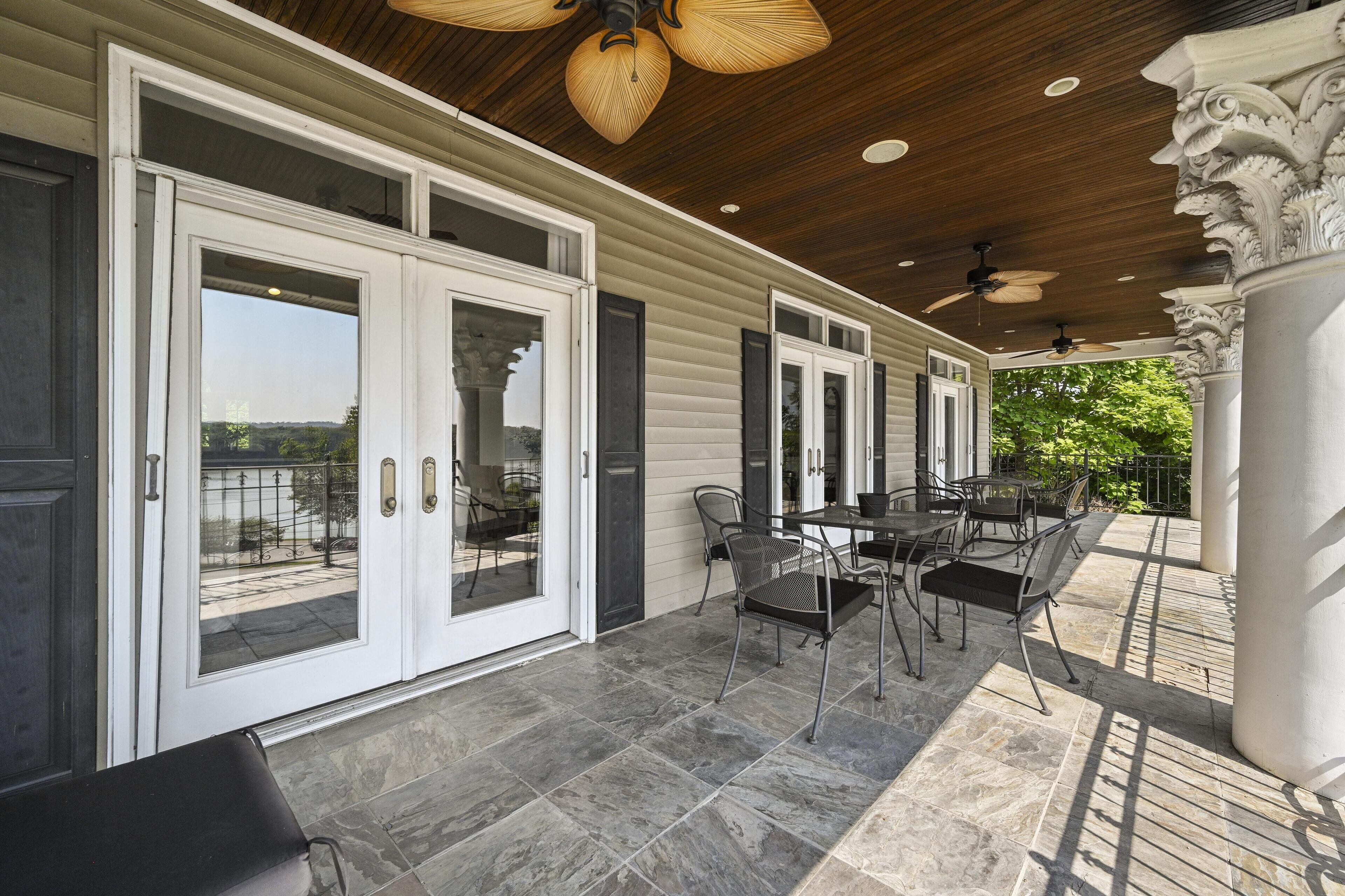 Une terrasse couverte avec un espace repas, de grandes portes-fenêtres coulissantes et une vue sur l’extérieur.
