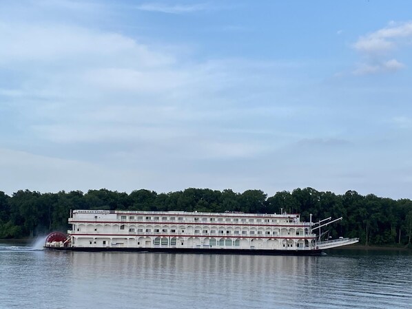 Un gran barco de pasajeros fluvial con una destacada sala de mando y varios niveles de balcones.